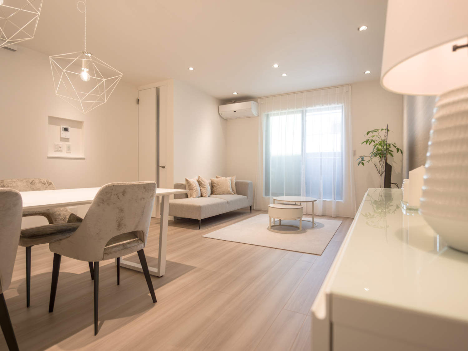 電球色のダウンライトと間接照明を組み合わせ、壁面や天井に陰影をつくったホテルライクな室内空間。光の配置で奥行きと落ち着きを演出した照明計画の実例