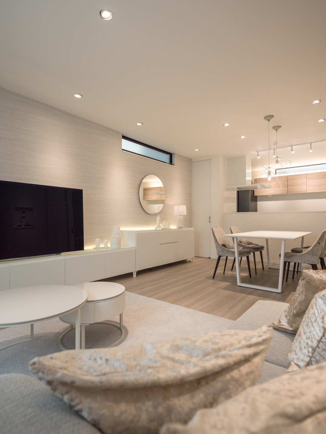 既存のダウンライト配置を活かしながら照明計画を見直し、器具の再選定と間接照明を組み合わせることで、電球色でも明るさと心地よさを両立した空間に整えています。ホワイトとライトグレーを基調とすることで、光を美しく受け止めるホテルライクなリビングを実現しました。