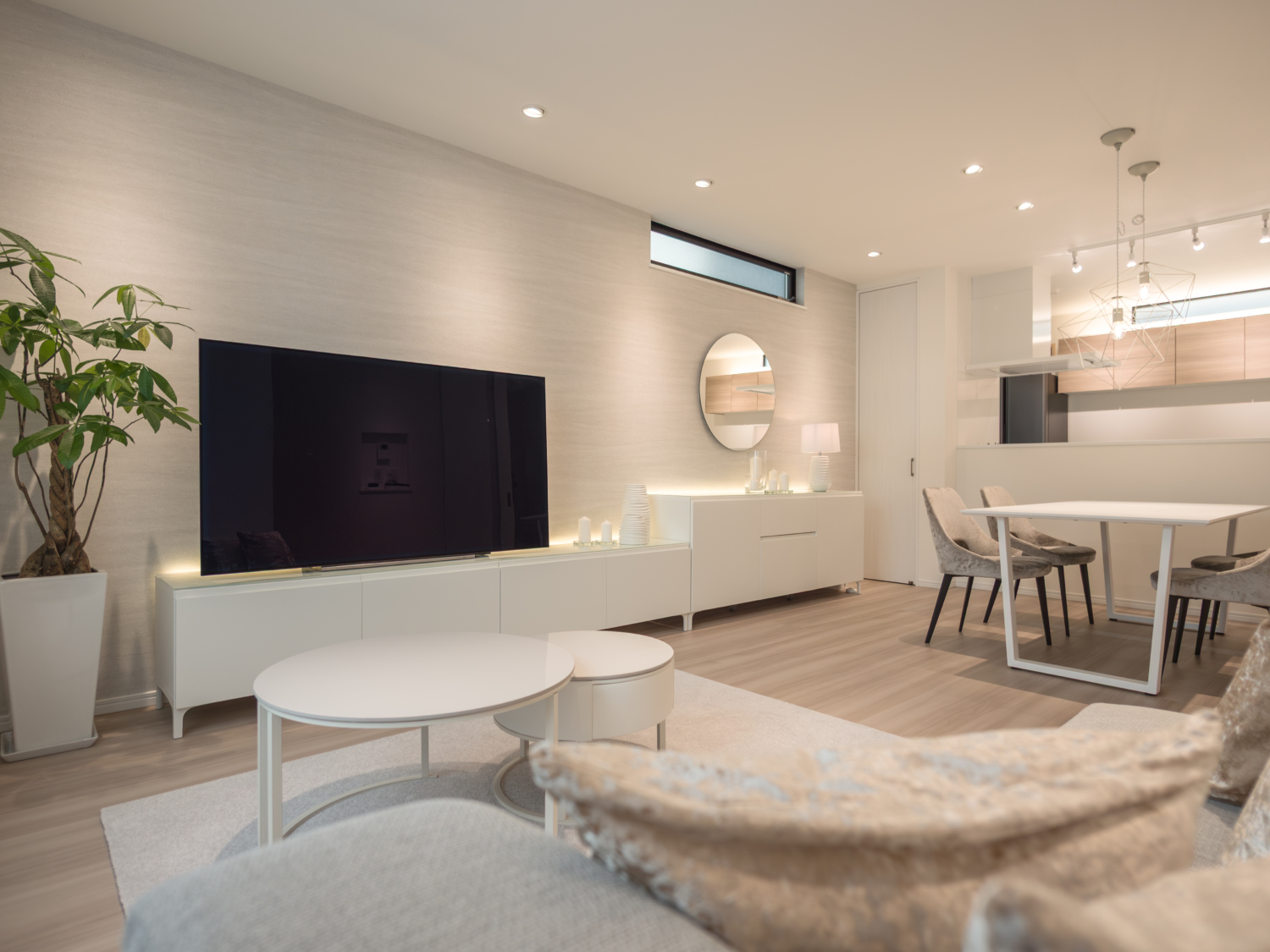 東大阪市の新築戸建てにおけるホテルライクなリビングインテリア。ホワイトとライトグレーを基調に、照明計画と間接照明で陰影を演出した空間