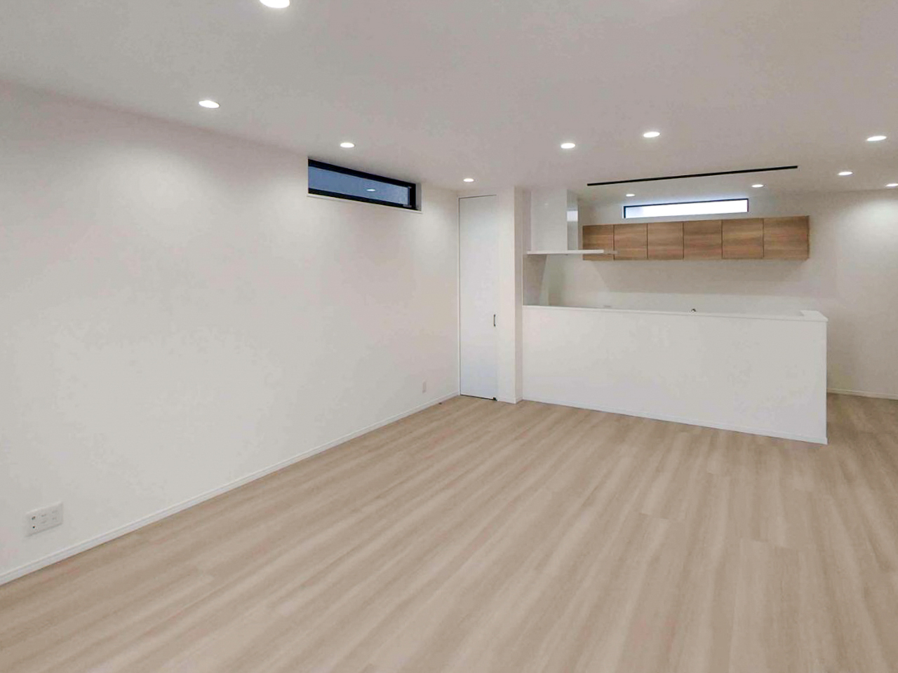 白色ダウンライトで均一に照らされた室内空間。明るさはあるが陰影が少なく、ホテルライクな雰囲気が出にくい照明状態の例